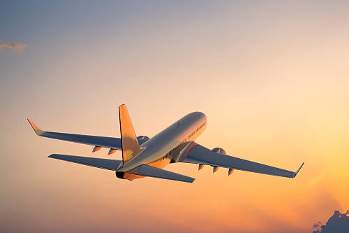 Passanger airplane flying above clouds in evening.